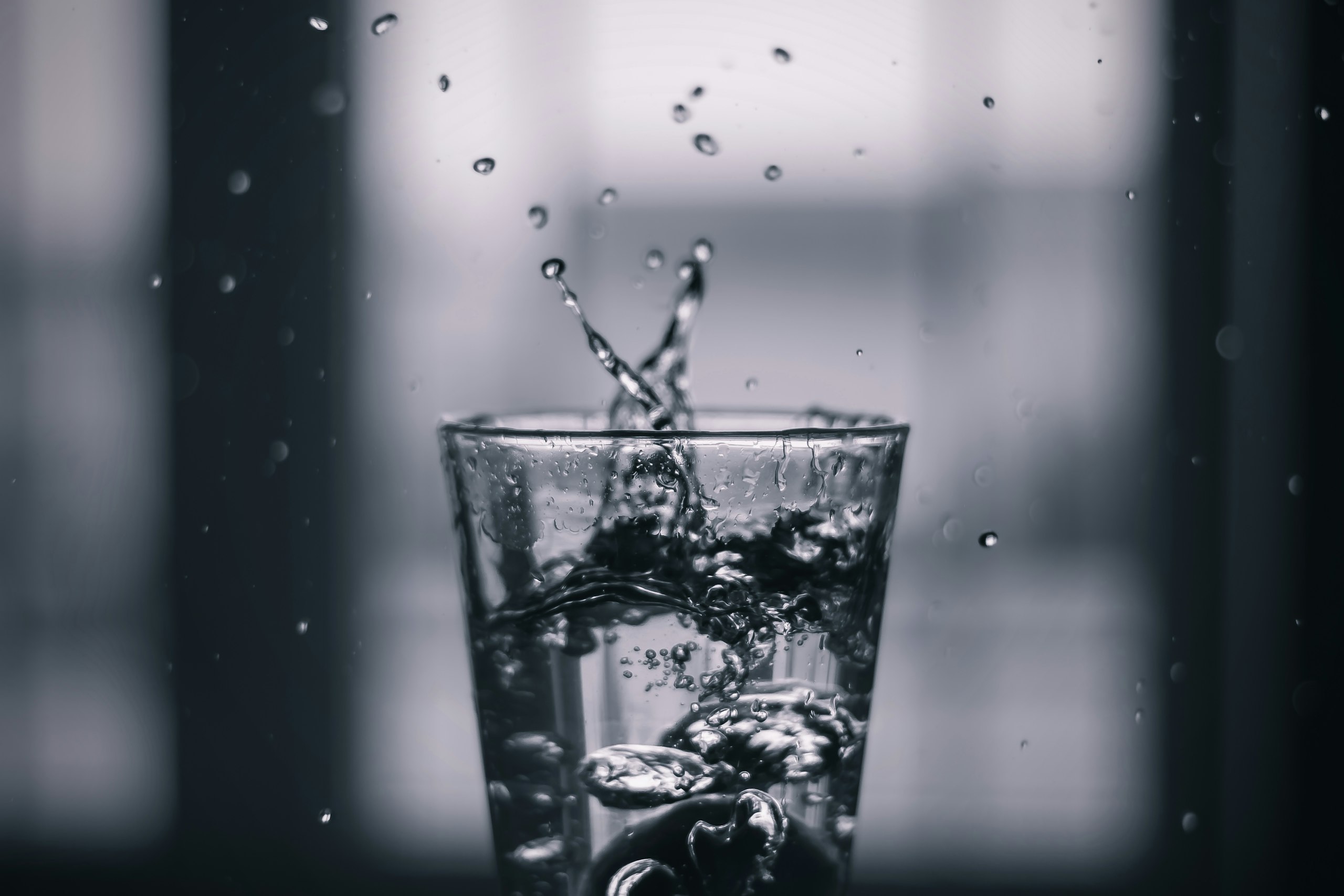 Water pouring into a clear drinking glass